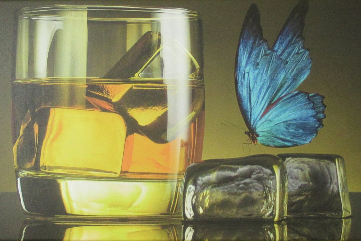 Leinwand in der Stüva: ein Glas mit Eiswürfeln, darüber ein blauer Schmetterling.
